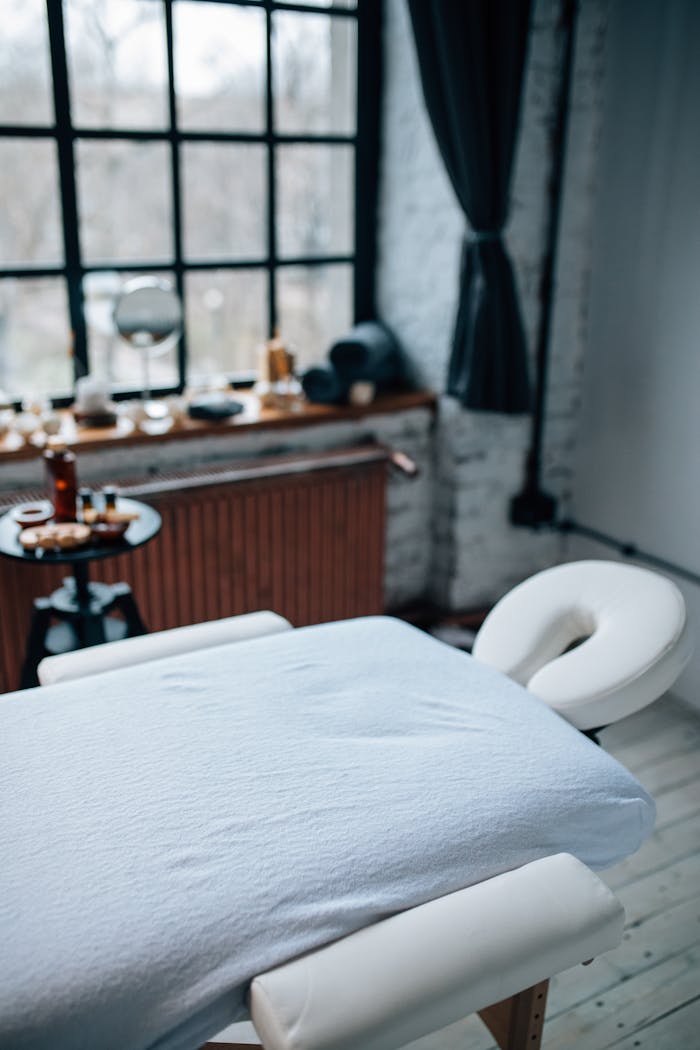 Cozy massage room featuring a comfortable table and natural light. Perfect for relaxation.